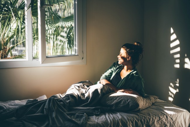 Woman resting near window at home.