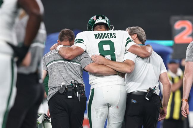 Aaron Rodgers of the New York Jets is helped off the field after suffering an apparent injury after being sacked by Leonard Floyd of the Buffalo Bills during a game at MetLife Stadium on September 11, 2023 in East Rutherford, New Jersey.