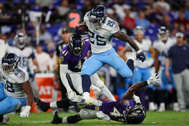 Hassan Haskins #25 of the Tennessee Titans jumps over Nate McCrary #47 of the Baltimore Ravens during the second half at M&T Bank Stadium on August 11, 2022 in Baltimore, Maryland.