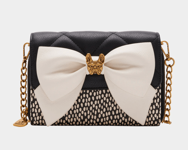 A Betsey Johnson chain wallet with a white bow accent and metal bulldog charm