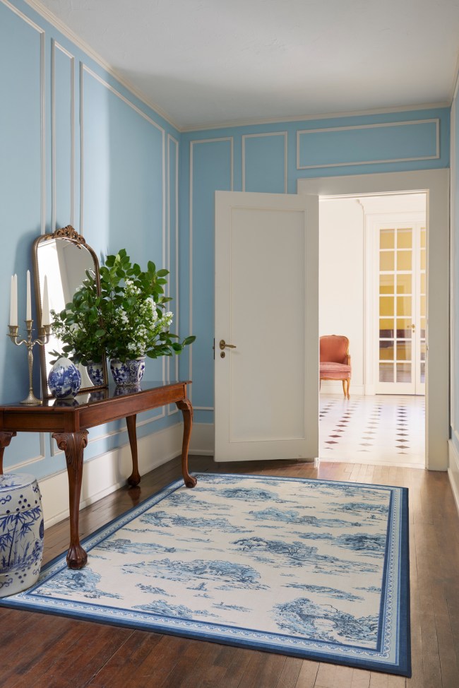 A blue and white rug in the hallway.