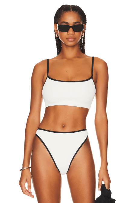 A model wearing the L*SPACE Adalyn Bikini Top in white and black