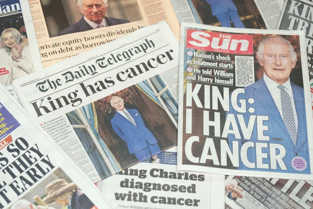 Pile of newspapers with headlines concerning King Charles' cancer diagnosis. 