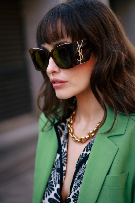 A fashion week guest wearing oversized YSL sunglasses.