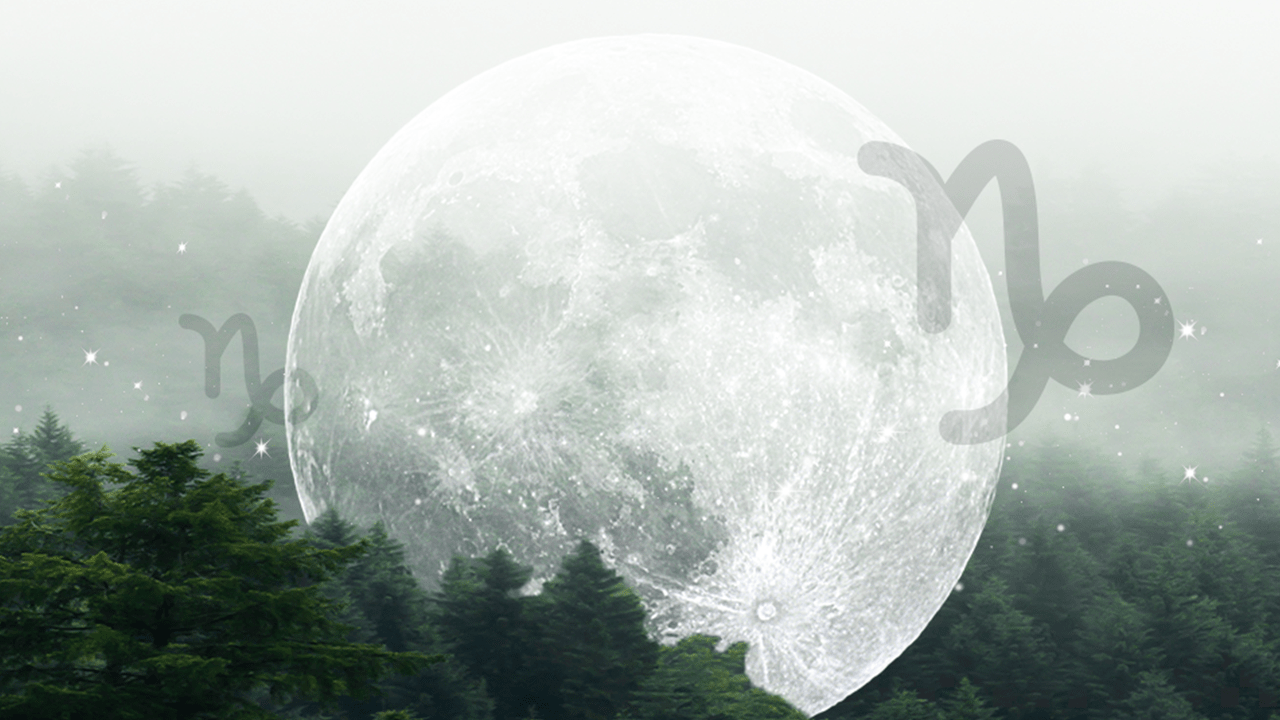 A full moon in Capricorn hanging over a foggy mountain covered in trees
