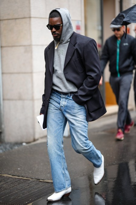 STYLECASTER | Men's outfit, grey hoodie, black blazer, light-wash jeans.