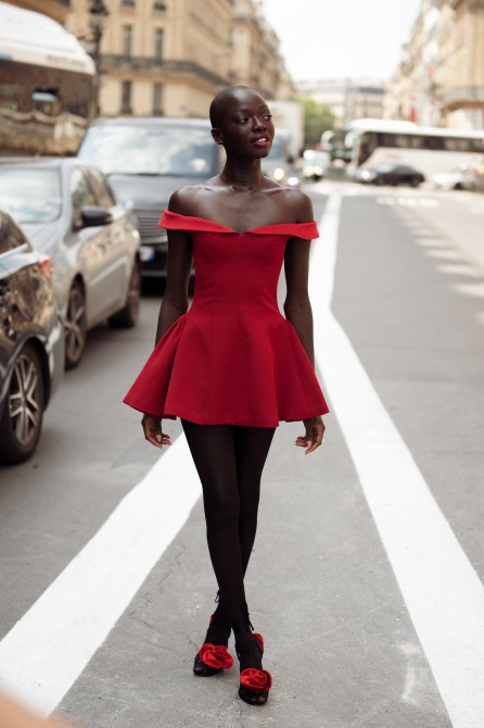 A woman wears red mini dress and shoes with roses