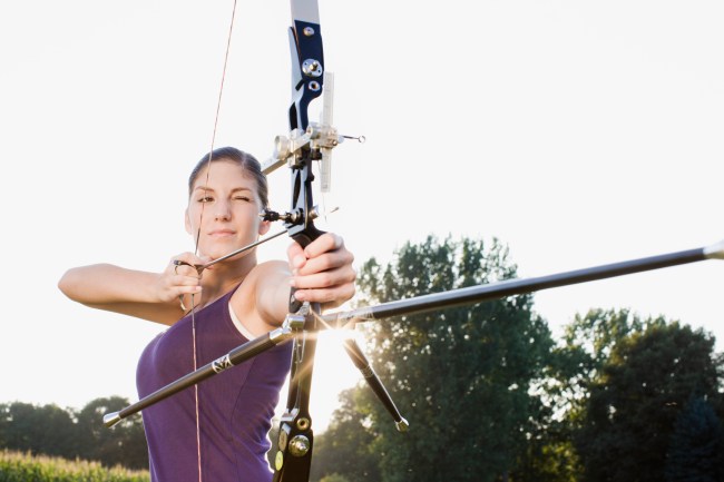 Young woman aiming a bow and arrow