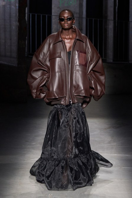 A model wearing a leather bomber jacket.