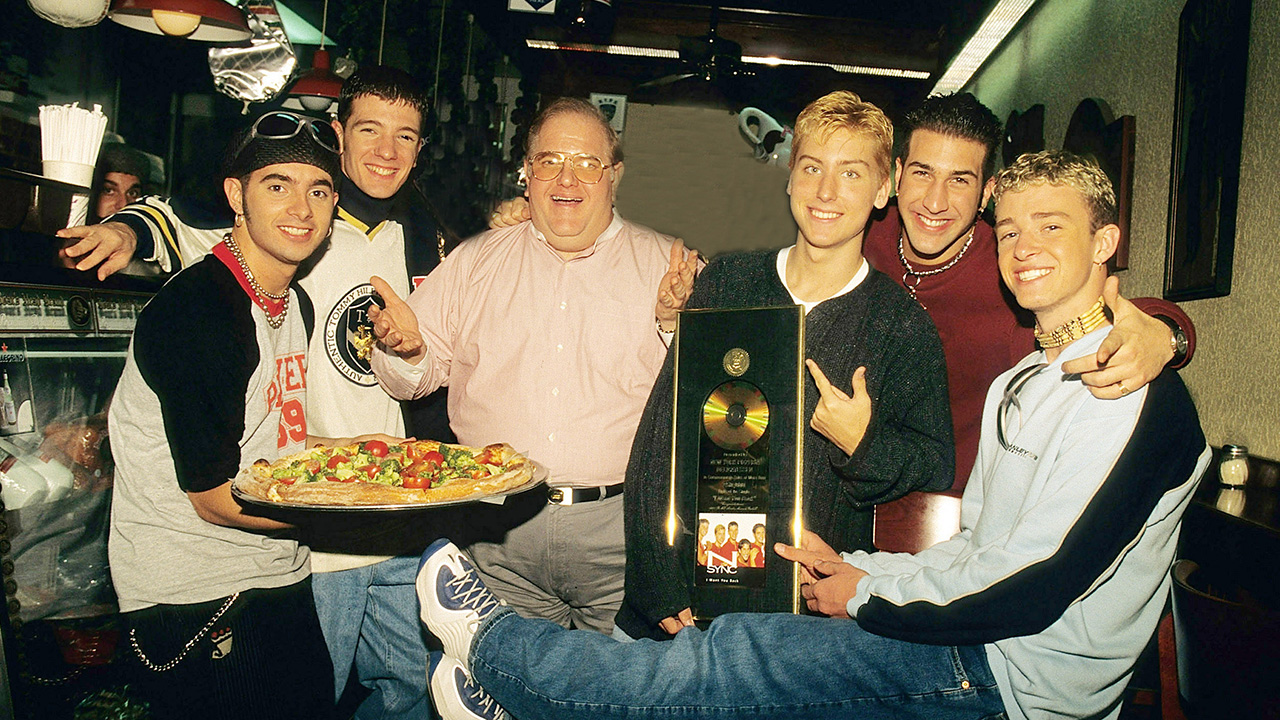 Lou Pearlman poses with N'Sync Chris Kirkpatrick,  JC Chasez,  Lance Bass,  Joey Fatone and Justin Timberlake seen at N.Y.P.D. pizza in Miami, circa 1996.