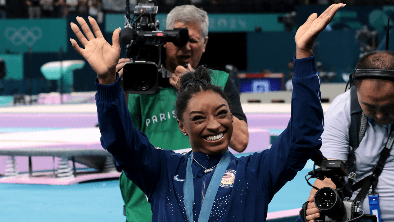 Gold medalist Simone Biles of Team United States waves to the crowd after competing in the Artistic Gymnastics Women's All-Around Final on day six of the Olympic Games Paris 2024 at Bercy Arena on August 01, 2024 in Paris, France.