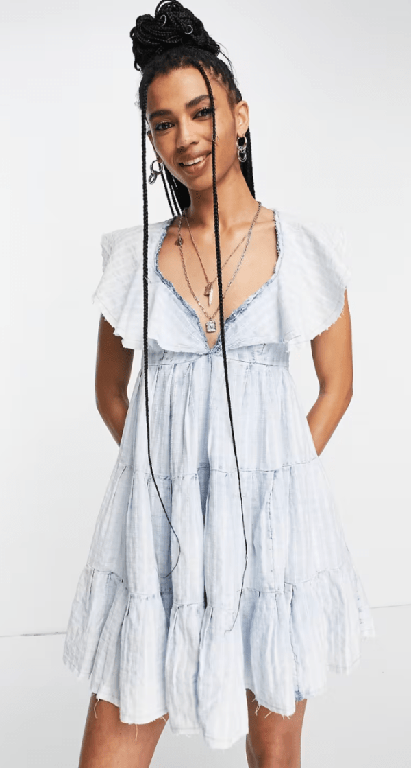 A model wearing the Free People Undone Tiered Mini Dress in a light blue colorway