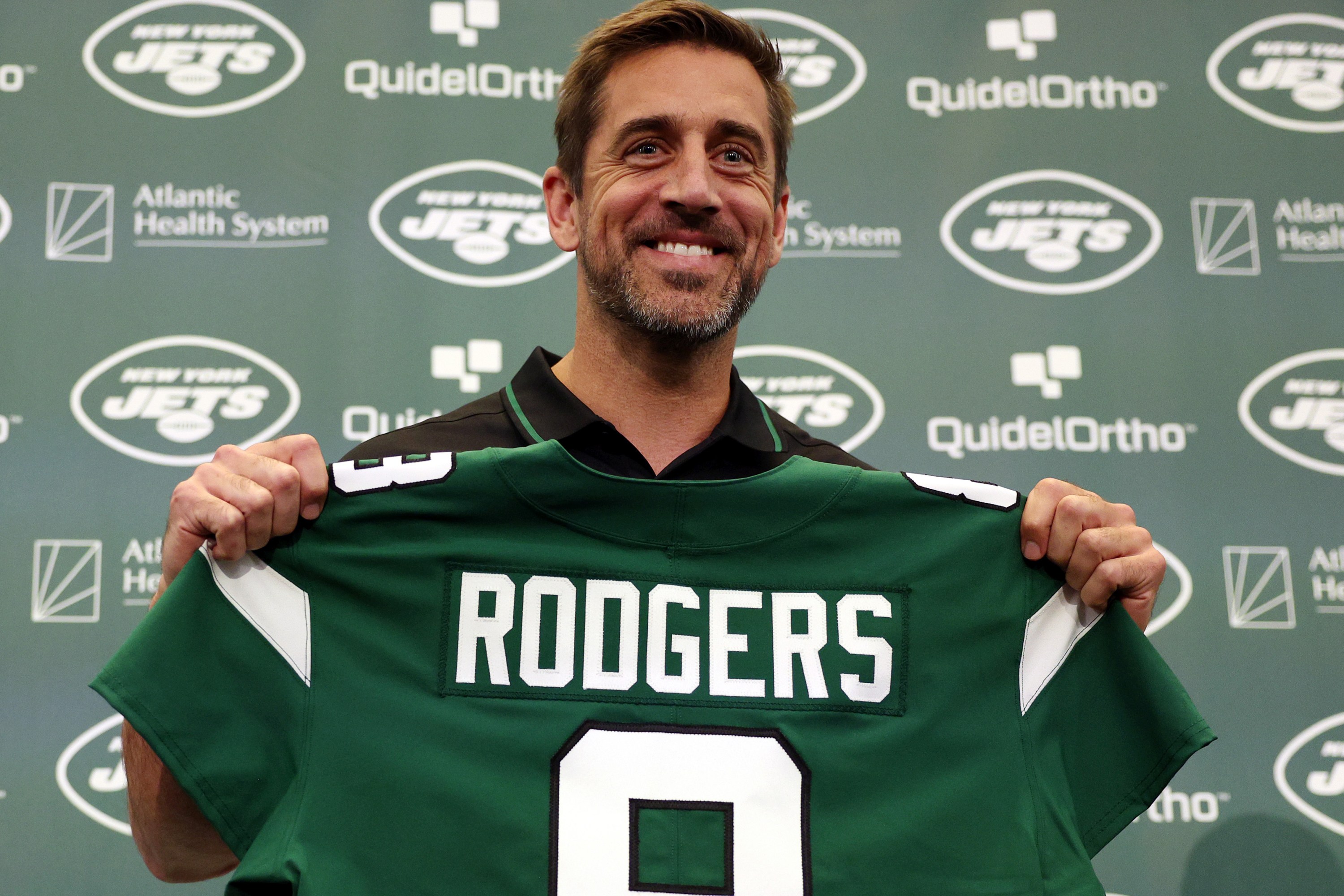 New York Jets quarterback Aaron Rodgers poses with a jersey during an introductory press conference at Atlantic Health Jets Training Center on April 26, 2023 in Florham Park, New Jersey.