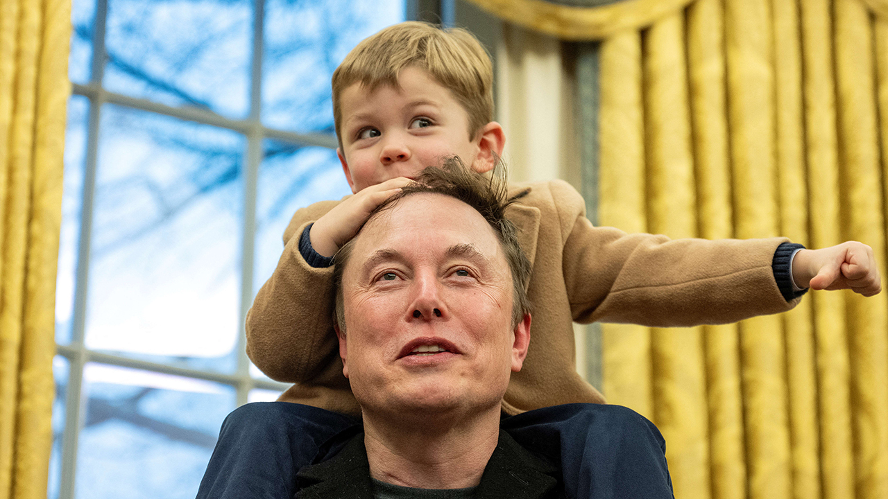 Elon Musk carries his son X Æ A-Xii on his shoulders while speaking in the Oval Office of the White House in Washington, DC, on February 11, 2025. Tech billionaire Elon Musk, who has been tapped by President Donald Trump to lead federal cost-cutting efforts, said the United States would go "bankrupt" without budget cuts. Musk leads the efforts under the newly created Department of Government Efficiency (DOGE), and was speaking at the White House with Trump, who has in recent weeks unleashed a flurry of orders aimed at slashing federal spending.