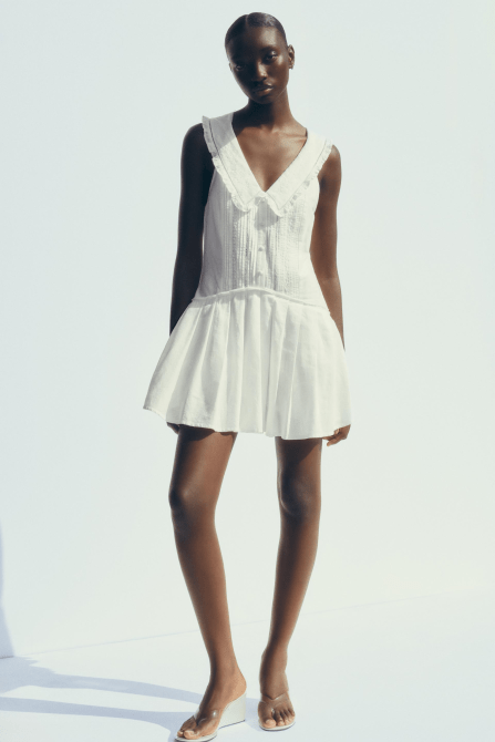 A model wearing the Zara Pleated Peter Pan Collar Short Dress in white