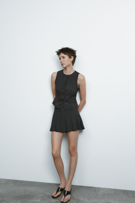 A Zara model wearing the Pleated Skort in mid-gray with a matching vest top