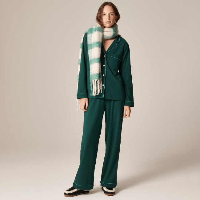 A model wearing the J.Crew Dreamy Cotton-Blend Pajama Pant Set in green with a green and white plaid scarf and black slippers