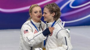 MILAN, ITALY - February 08:  Amber Glenn embraces Ilia Malinin as the United States team celebrates their gold medal win on the podium after the Figure Skating, Team Event at the Milano Ice Skating Arena at the Milano Cortina Winter Olympic Games 2026 on February 8th, 2026 in Milan, Italy.